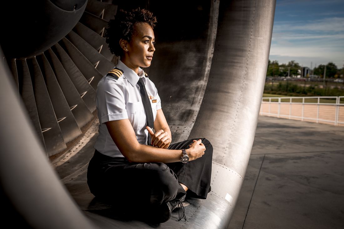 A pilot in uniform seated inside an aircraft engine cowling — photo by Terrence Bowen on Pexels
