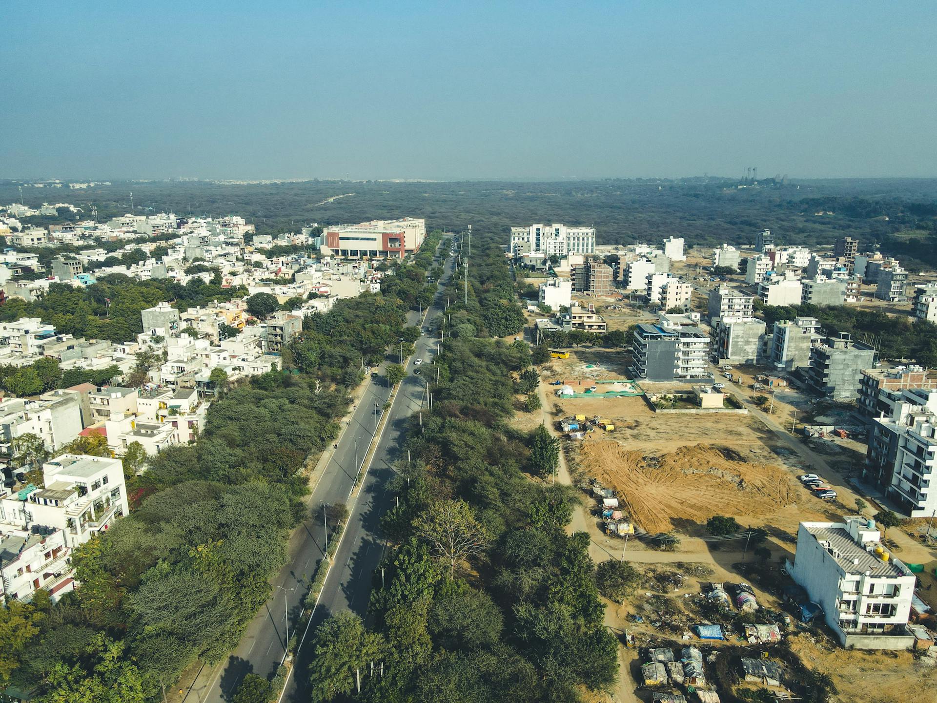 Drone shot capturing the expansive urban landscape and development in Gurugram, India.