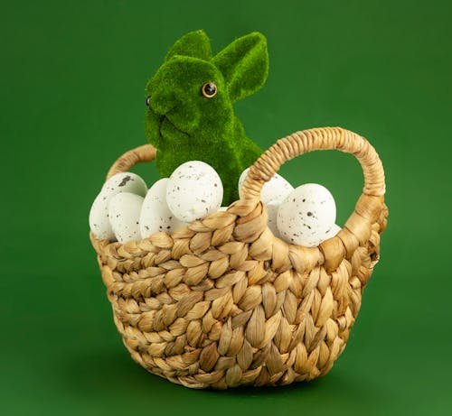 Green Bunny Figurine and White Eggs in Brown Woven Basket