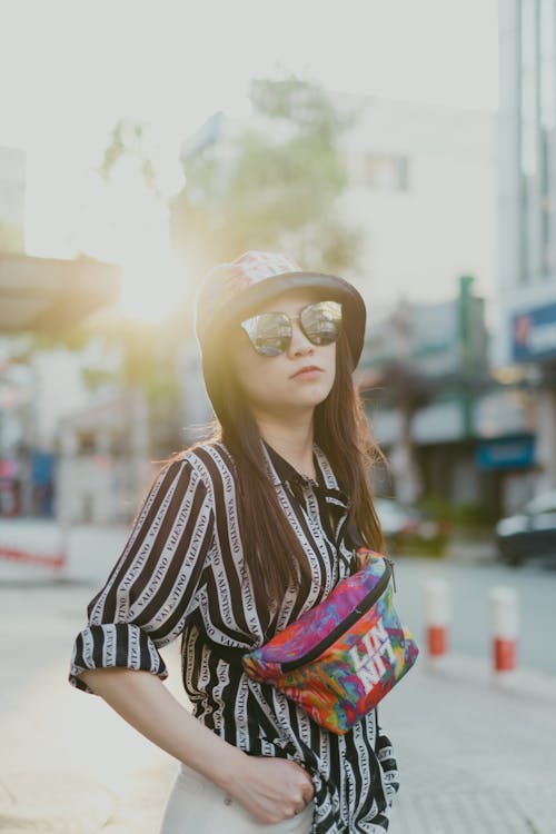Woman in Black and White Striped Long Sleeve Shirt Wearing Bucket Hat and Sunglasses