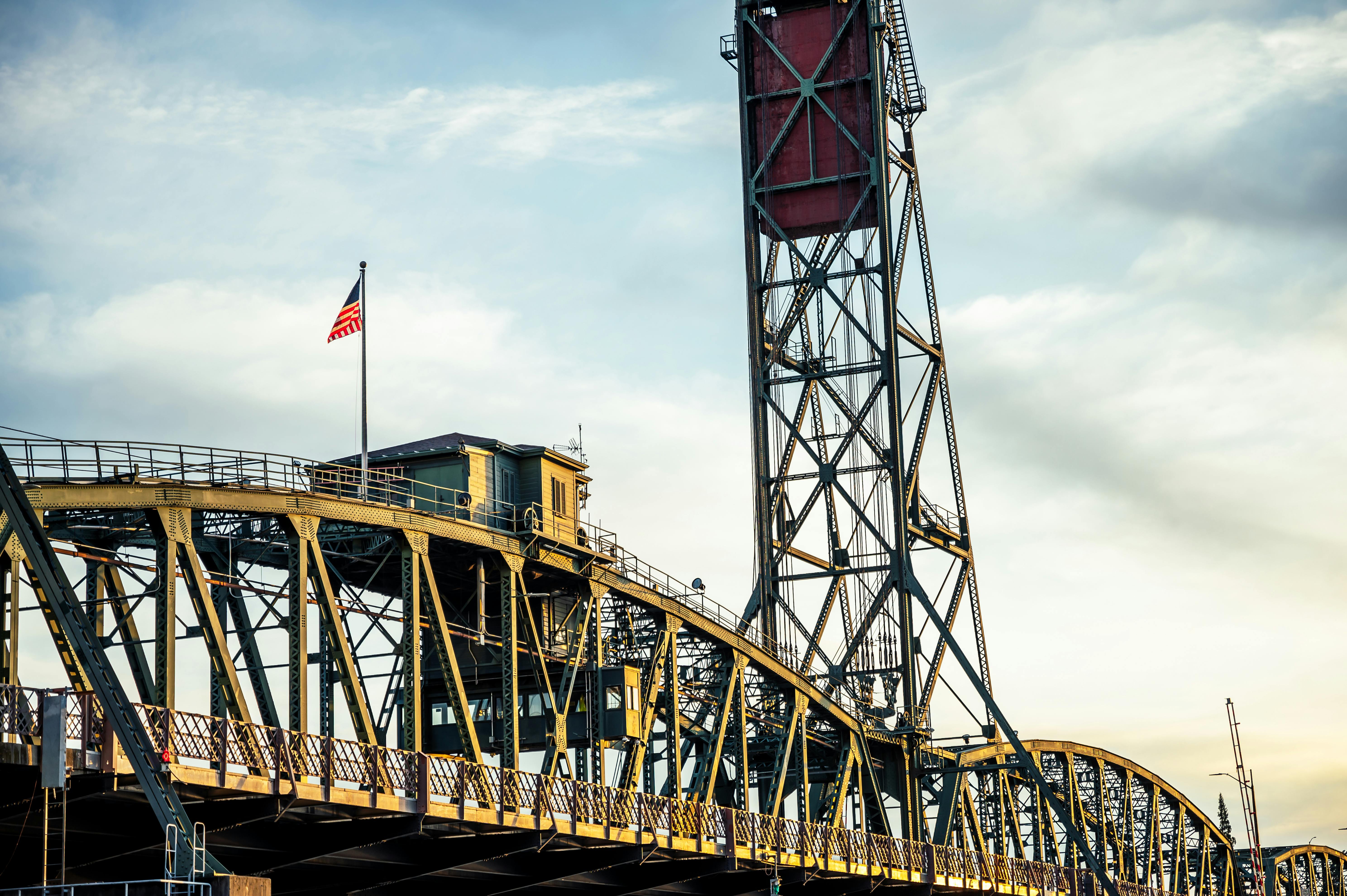 american flag on metal bridge against sundown sky