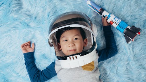 Free Baby in Blue and White Jacket Wearing Black and White Helmet Stock Photo