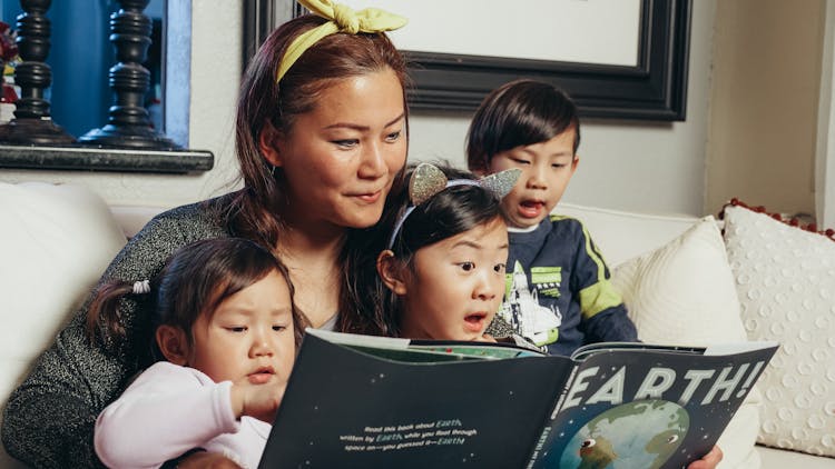 Woman Reading A Book With Her Kids