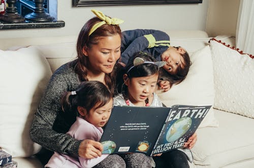 A Mother and Her Kids Reading a Book