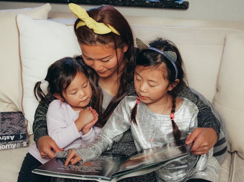 Free A Mother and Her Kids Reading a Book Stock Photo