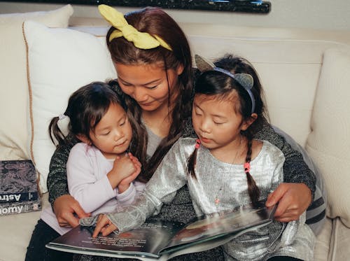 Kostenloses Stock Foto zu asiatische familie, ein buch lesen, kinder