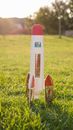 White and Red Toy Plane on Green Grass Field