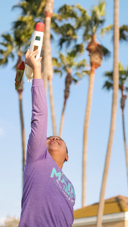 A Boy in Purple Long Sleeves Playing a Rocket