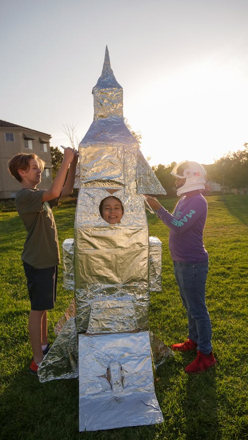 Two Boys Playing Rocket on a Grassy Field