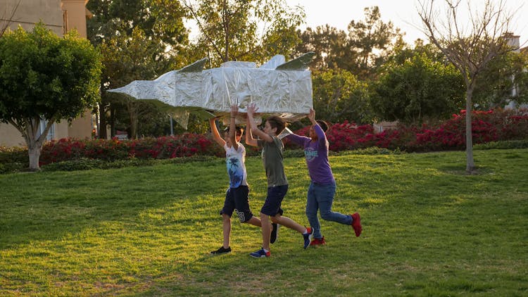 Boys Playing A Cardboard Rocket