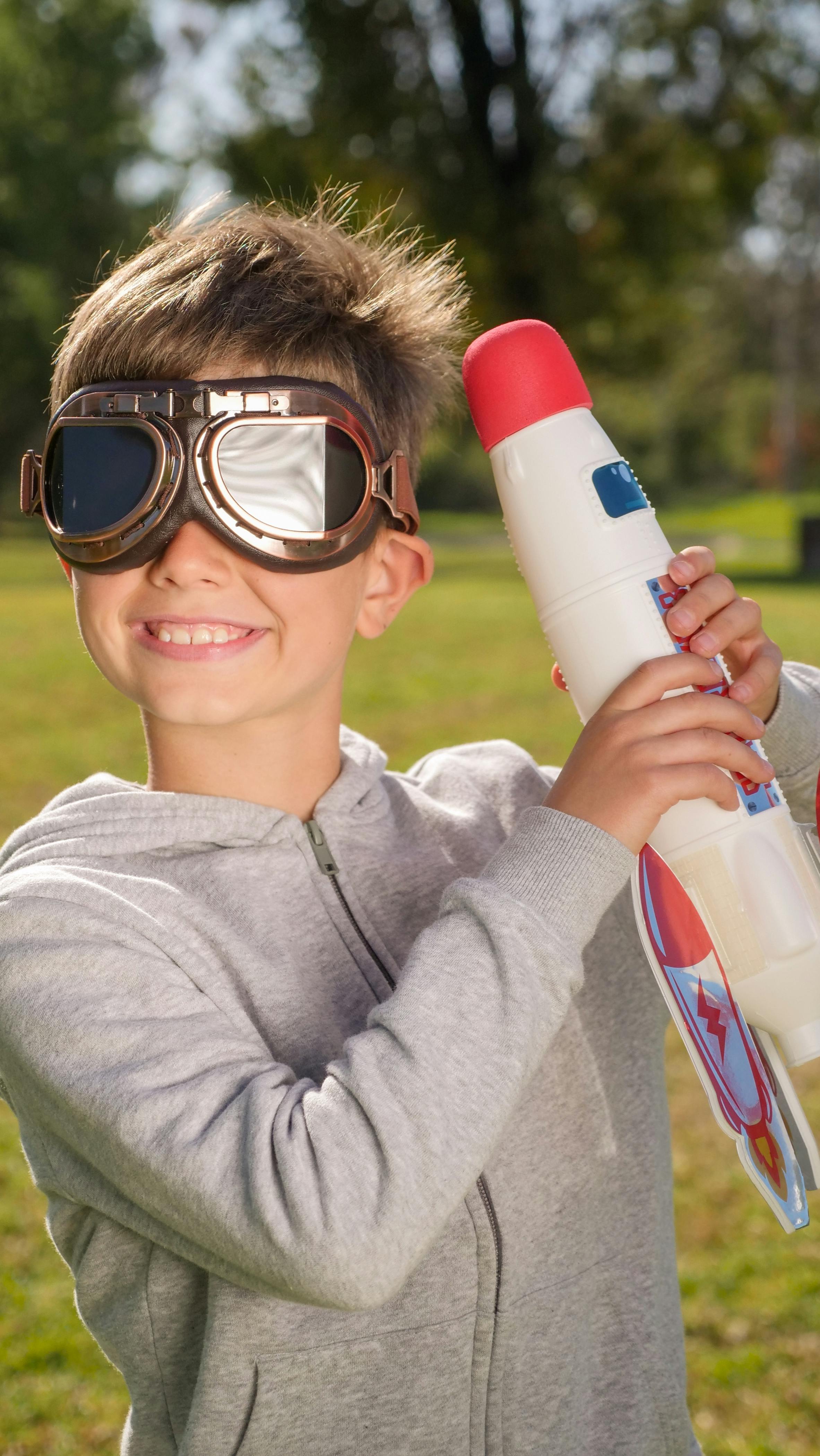 smiling young boy holding a toy rocket