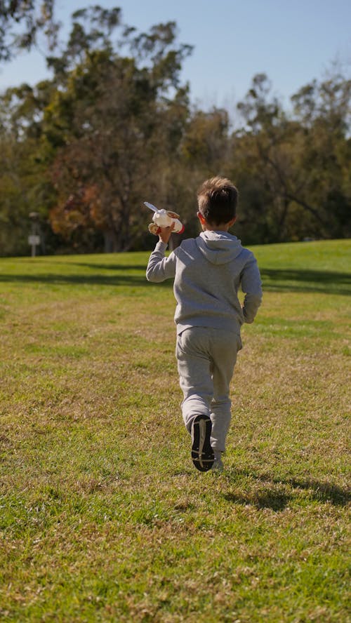 A Boy Running on Green Grass