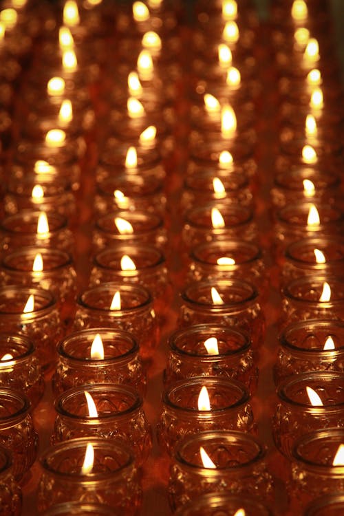 Burning Candles in Glass Jars Lined Up