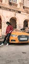 Ethnic man near car on road in street near building