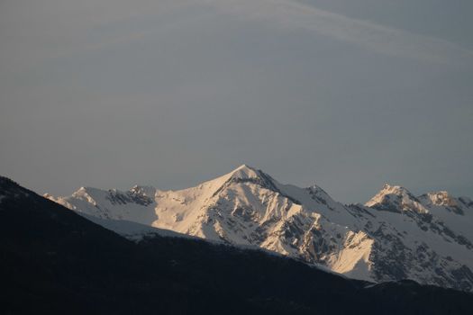 High mountains covered with hoarfrost against blue cloudless sky in snowy highland area on cold winter day in wild nature