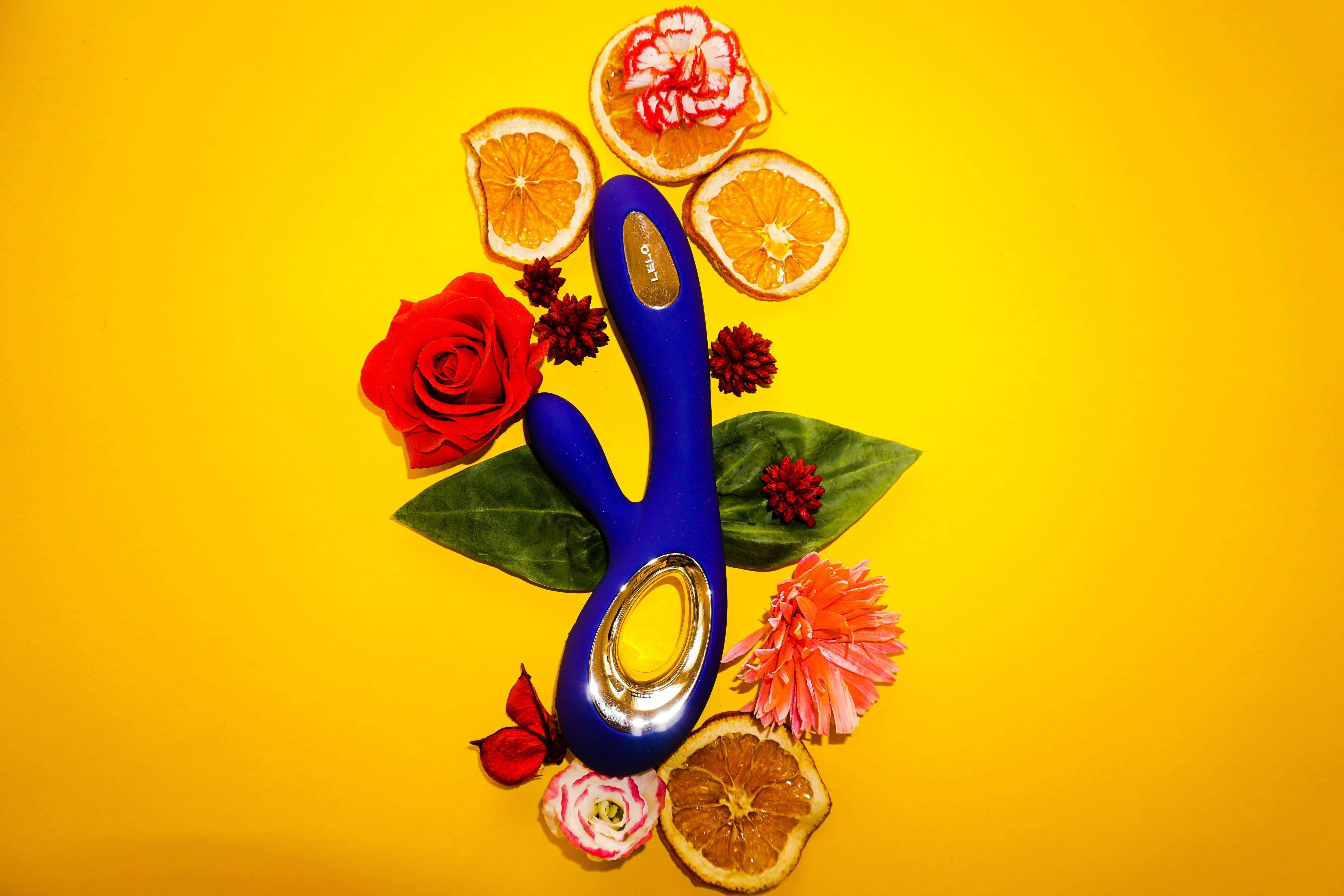 a vibrator with flowers and orange slices for decoration lying around it