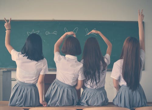 Ücretsiz El Işaretleri Yapıyor Okul üniforması Giyen Dört Kız Fotoğrafı Stok Fotoğraflar