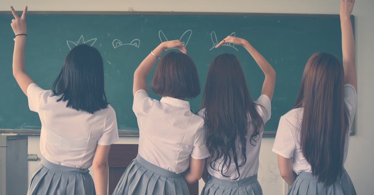 Photo of Four Girls Wearing School Uniform Doing Hand Signs