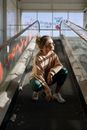 A Woman in Brown Sweater Squatting on a Conveyor