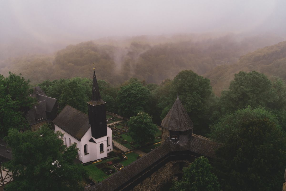 Biserica de sat invaluita in ceata, langa padure