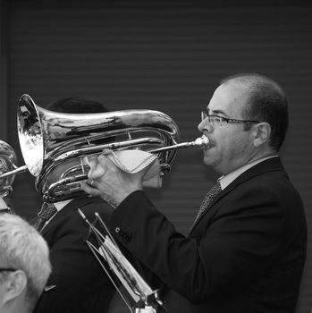 A black and white photo of a musician playing the tuba outdoors in Barcelona.
