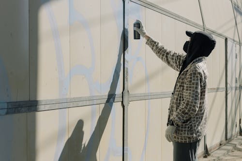 A man Spray Painting a Wall