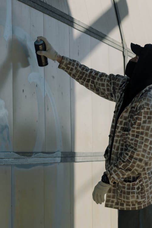 Person Painting the Wall Using Spray Paint 