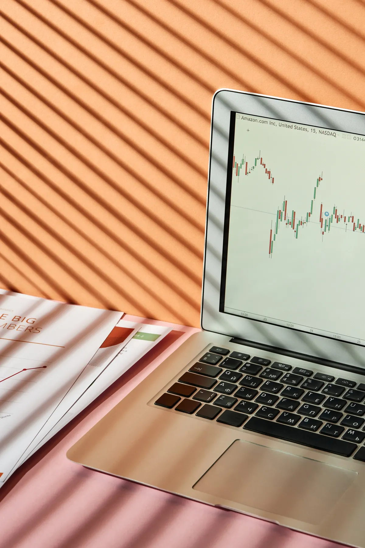 A laptop screen displaying a stock exchange price graph on a desk.