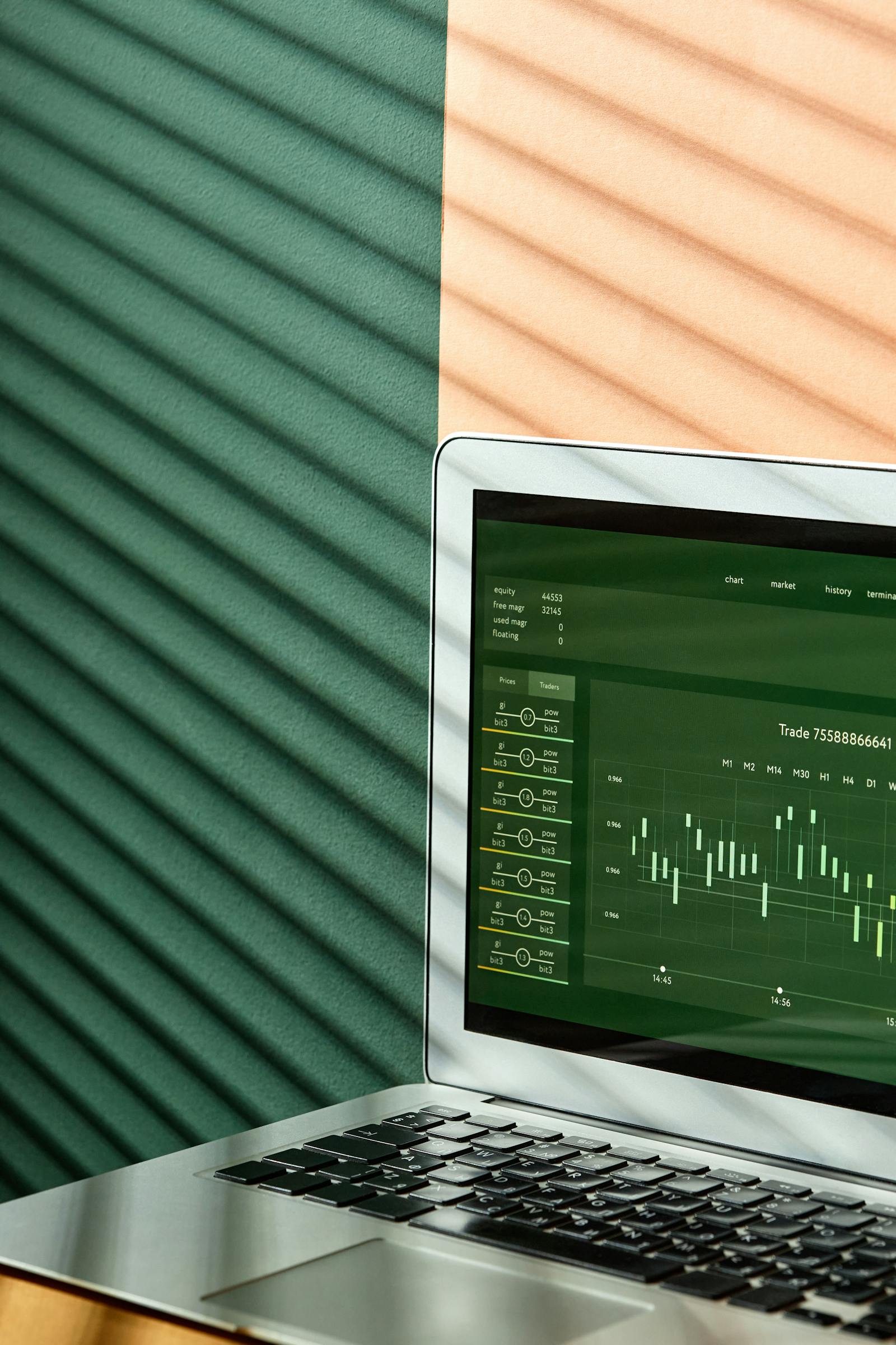 Portatile grigio con grafici finanziari colorati sullo schermo in primo piano