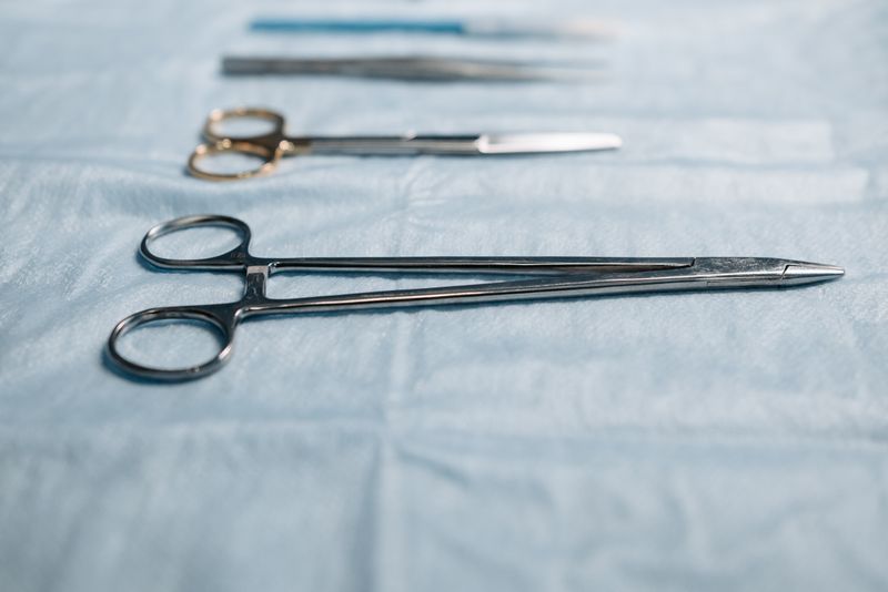 Close-up of surgical tools on a blue cloth in a medical setting