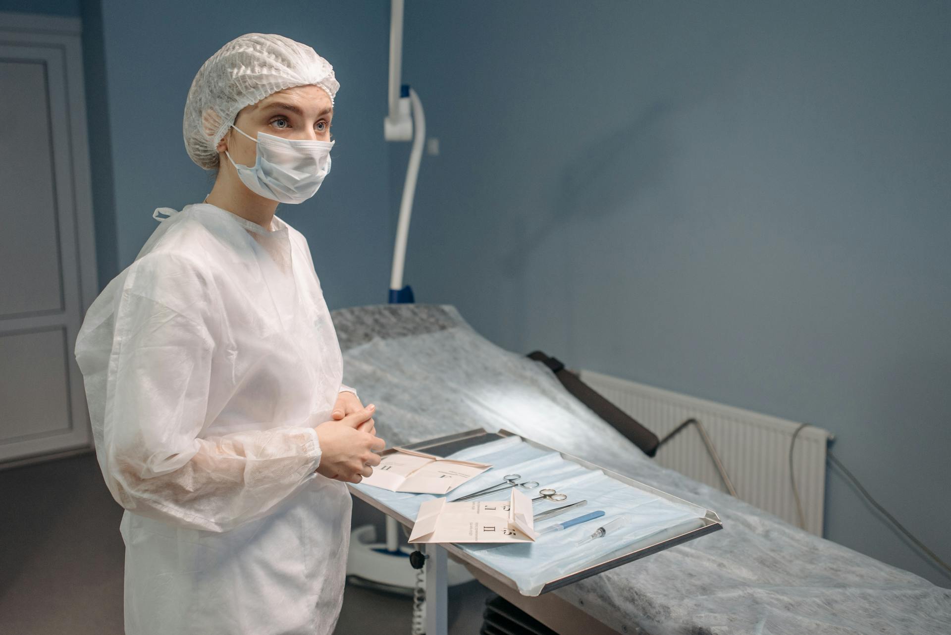 Woman in White Protective Suit Waiting Inside a Room