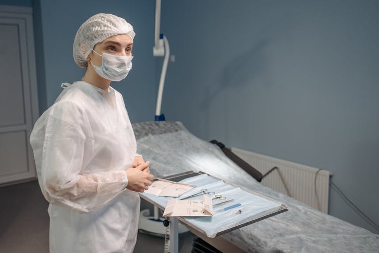 Woman In White Protective Suit Waiting Inside A Room