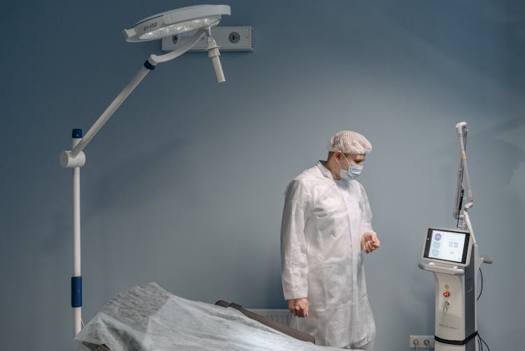 A Man Standing Beside The Medical Equipment