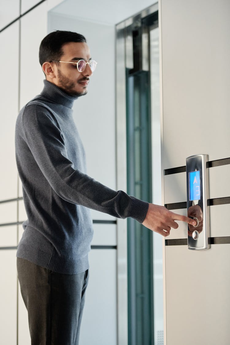 A Man Pressing An Elevator Button