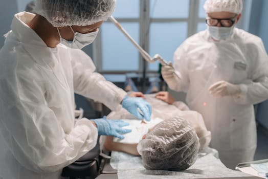Medical professionals in protective gear conducting a procedure in a sterile operating room.