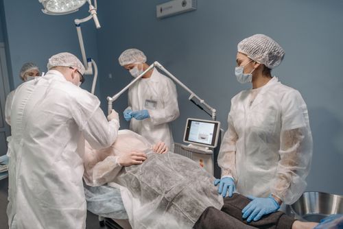 Free Healthcare professionals conducting a laser surgical procedure in a clinic setting. Stock Photo