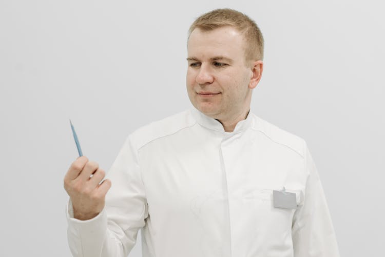 Portrait Of Man Wearing White Shirt And Holding A Pen 