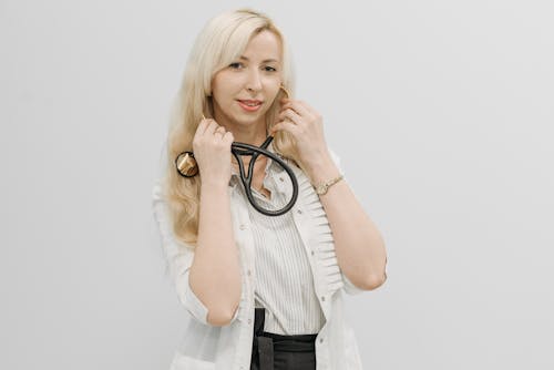 Woman in White Dress Shirt Holding Stethoscope