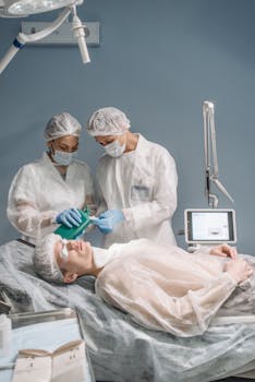 Healthcare professionals in sterile attire prepare a patient for a medical procedure in a modern operating room.