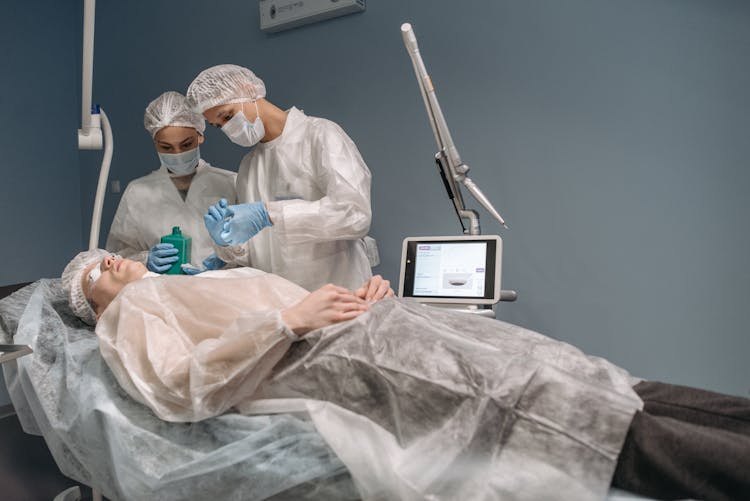 Doctors Looking At Patient On Bed In Operating Room