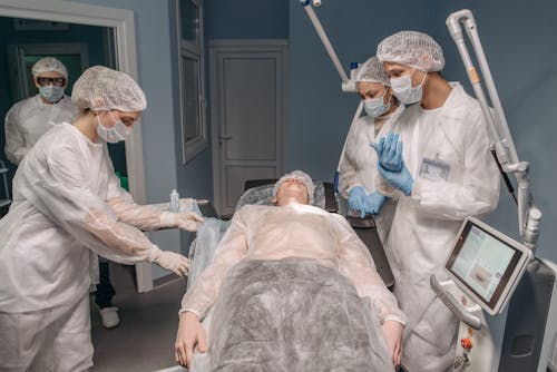 Free Medical Practitioners Standing at the Operating Table Stock Photo
