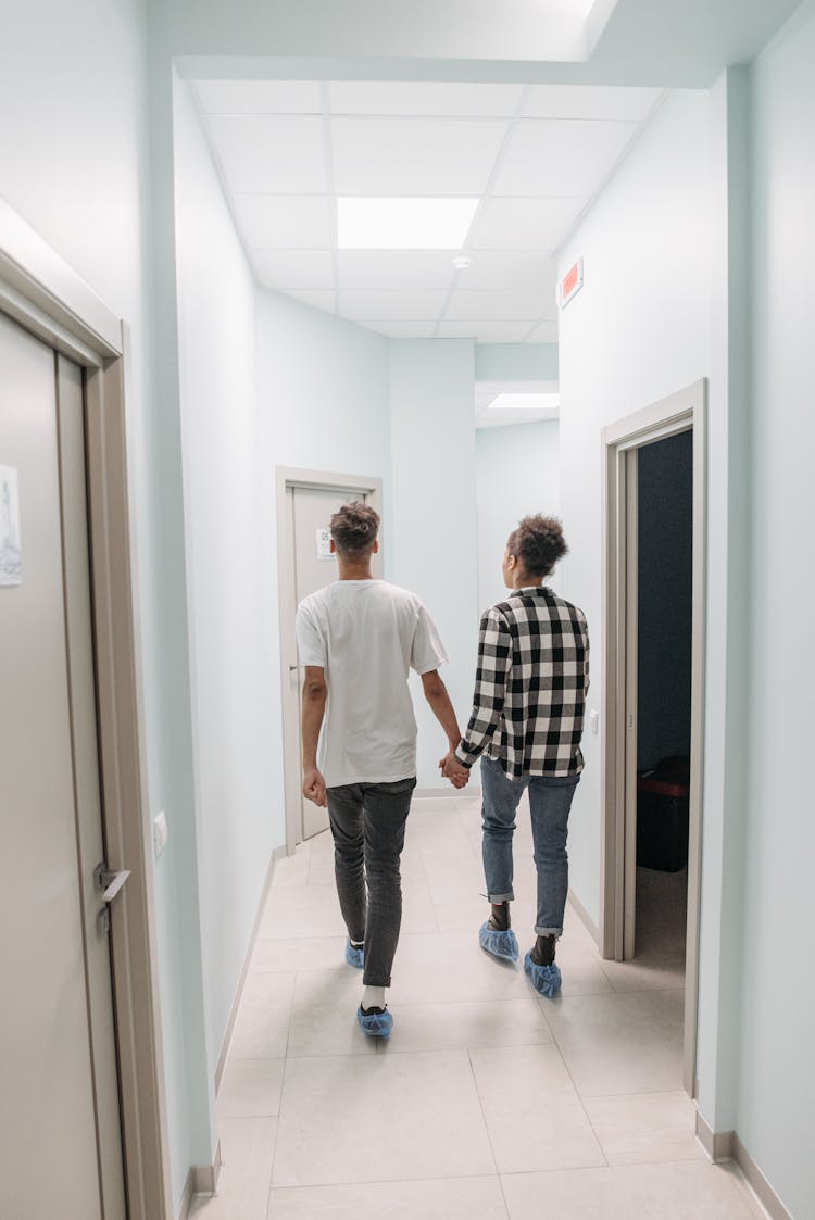 Back View Of A Couple Walking Together In A Hallway