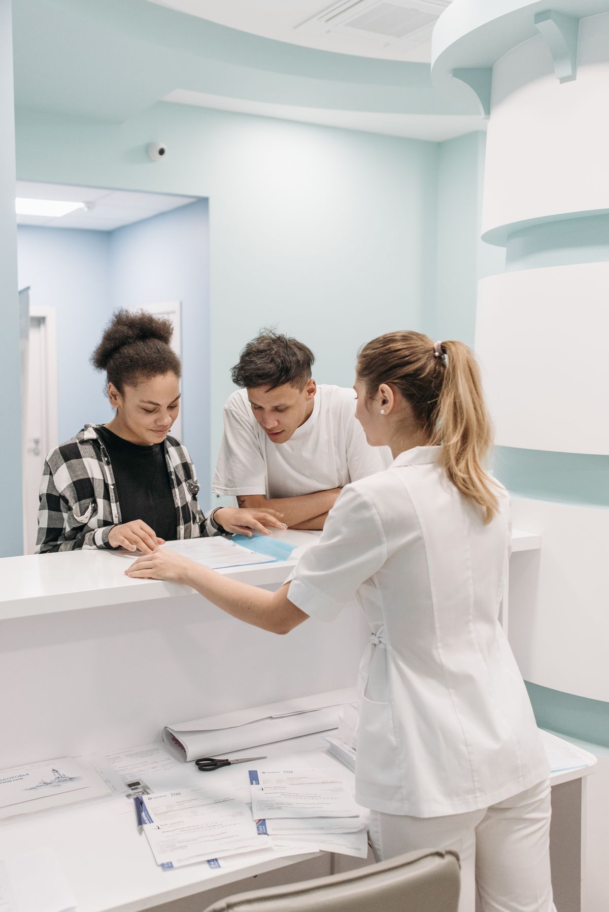 Healthcare staff member assisting patients at a clinic reception