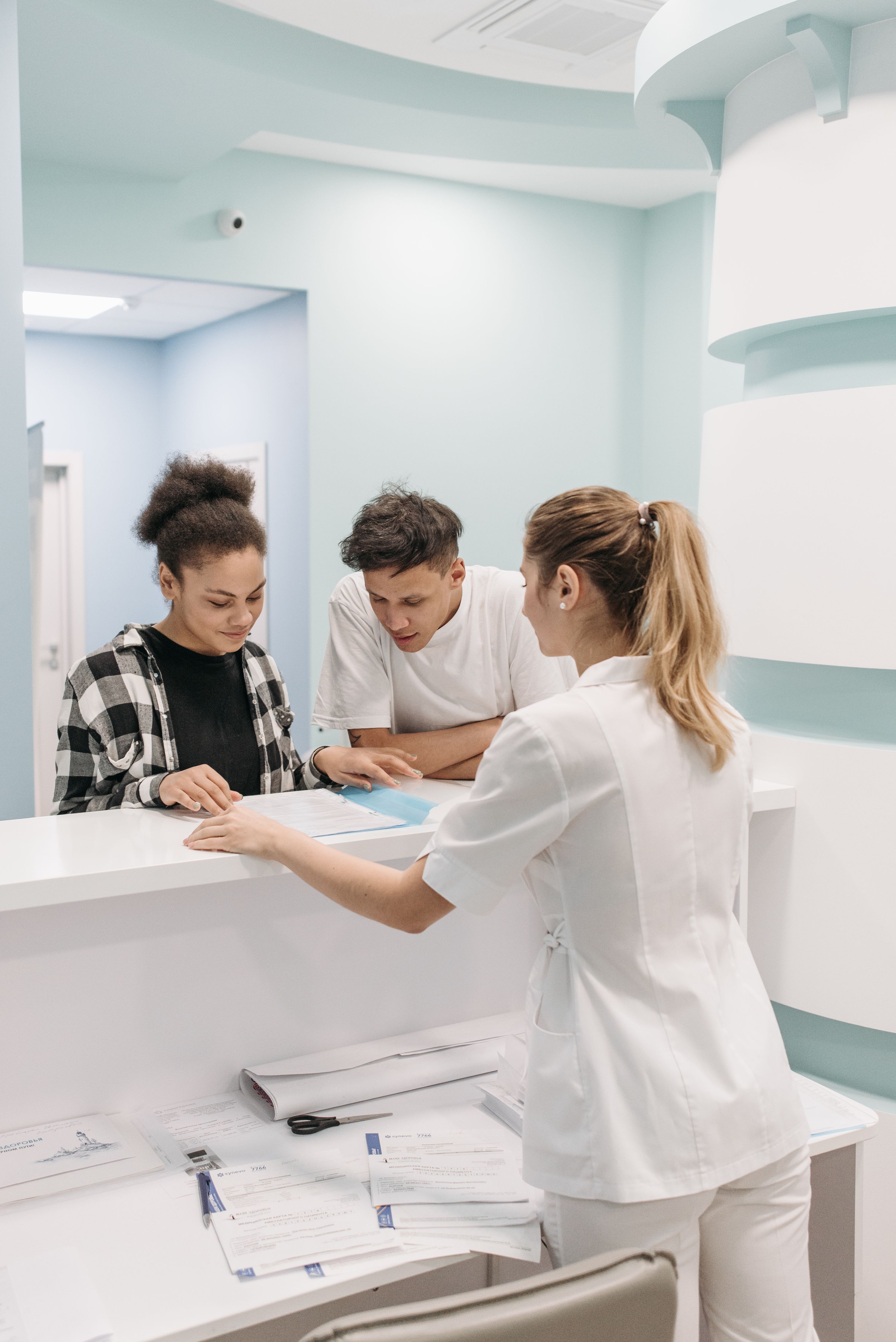 Nurse assisting patients at a medical reception desk