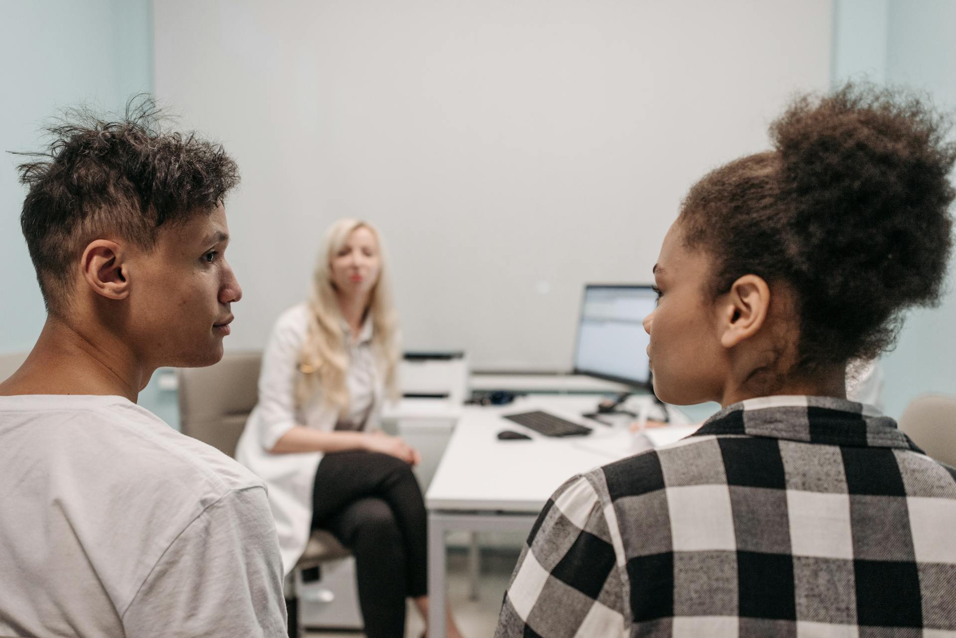 Diverse couple having a consultation with a healthcare professional in a modern office.