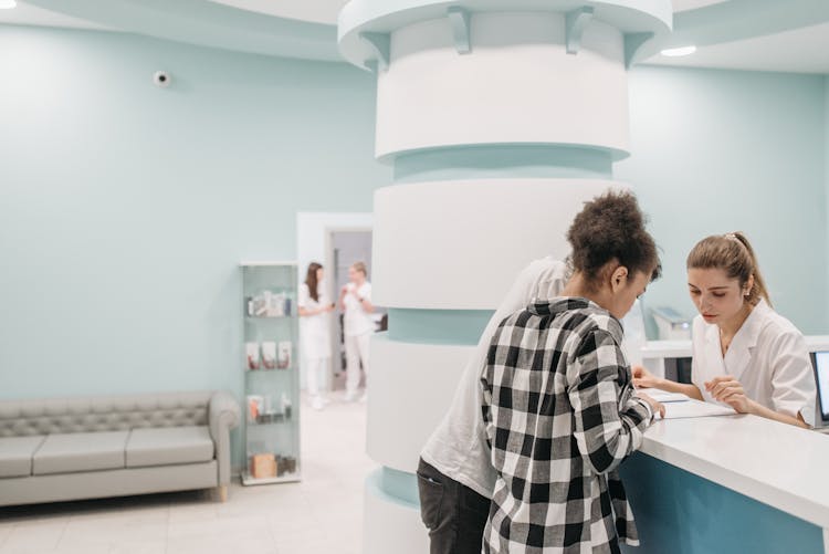 Couple Looking At Documents In Reception Of Medical Center