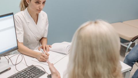 A doctor consults with a patient in a modern office setting, fostering communication.