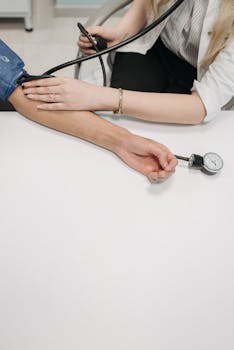 A medical practitioner checking a patient's blood pressure in a clinical setting.