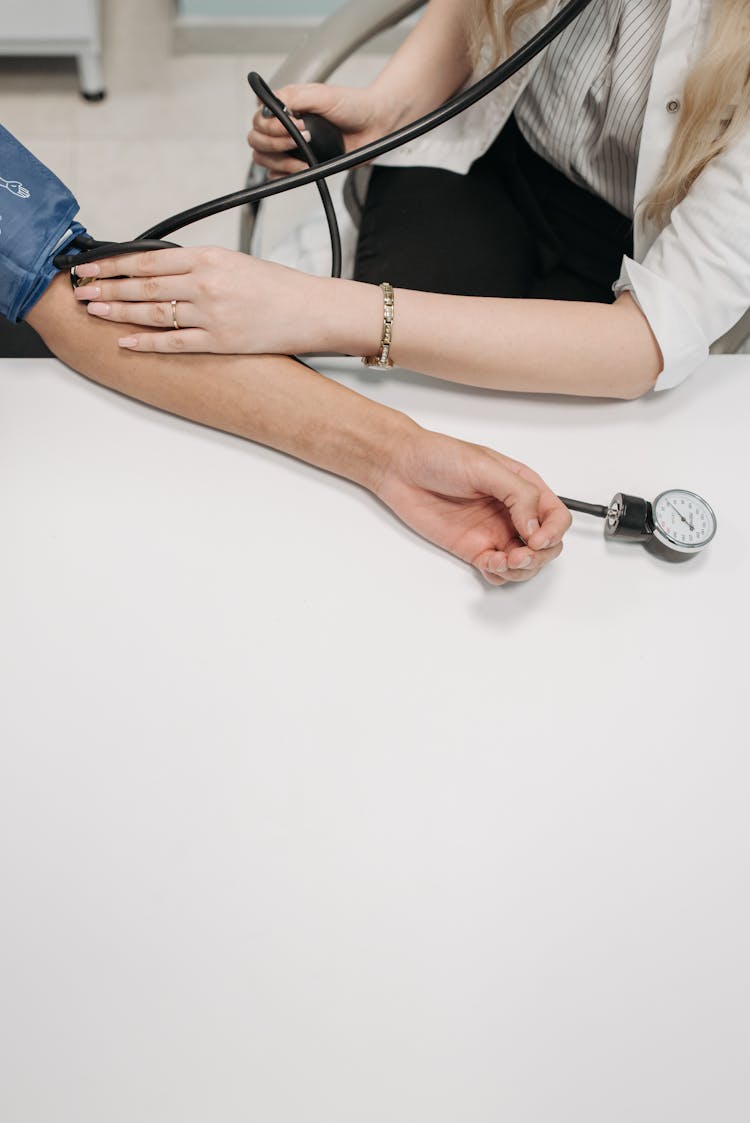 A Medical Practitioner Monitoring The Blood Pressure Of The Patient