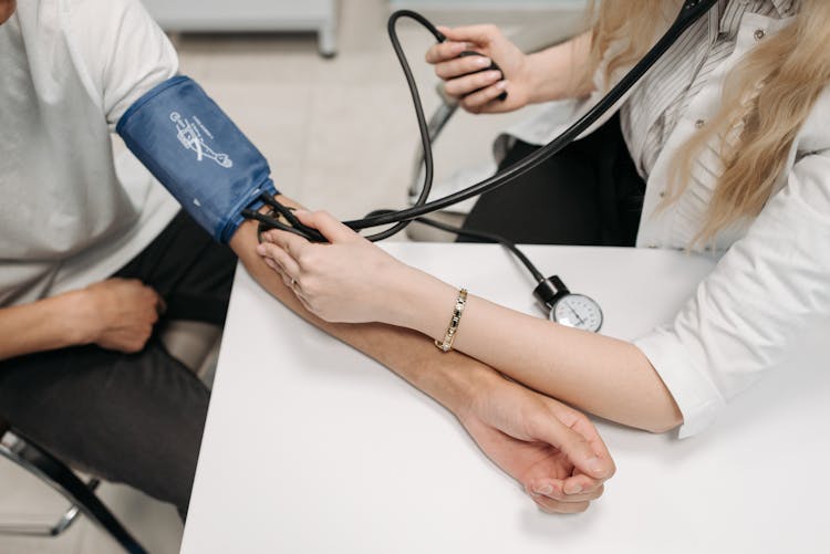 A Healthcare Worker Measuring A Patient's Blood Pressure Using A Sphygmomanometer